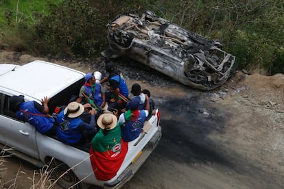 Guardias indígenas pasan junto a un carro destruido en el que presuntamente se transportaban miembros del Estado Mayor Central (EMC), en la vereda La Bodega de Toribío, el 19 de marzo.
