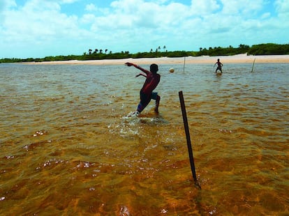 Dos chicos juegan en la playa mientras el agua sube. En la región más anegada de Maranhão, no se sabe cuál es la mayor dificultad: si jugar a la pelota en la arena fina o con el agua por la espinilla.