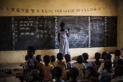 Una alumna escribe la lección en la pizarra durante una clase en la escuela de Bodouakro.
