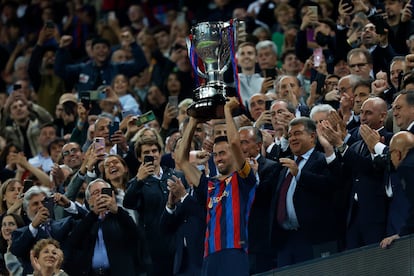 Busquets levanta el trofeo de campeón de Liga para el Barcelona en el palco del Camp Nou.