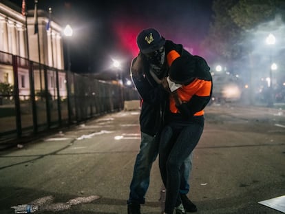 Homem socorre manifestante em Kenosha, Wisconsin, na terceira noite de protestos contra ação policial.