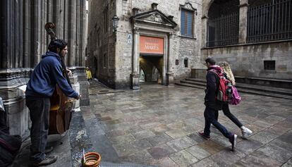 Un home toca un contrabaix enfront del museu Frederic Mares a Barcelona.