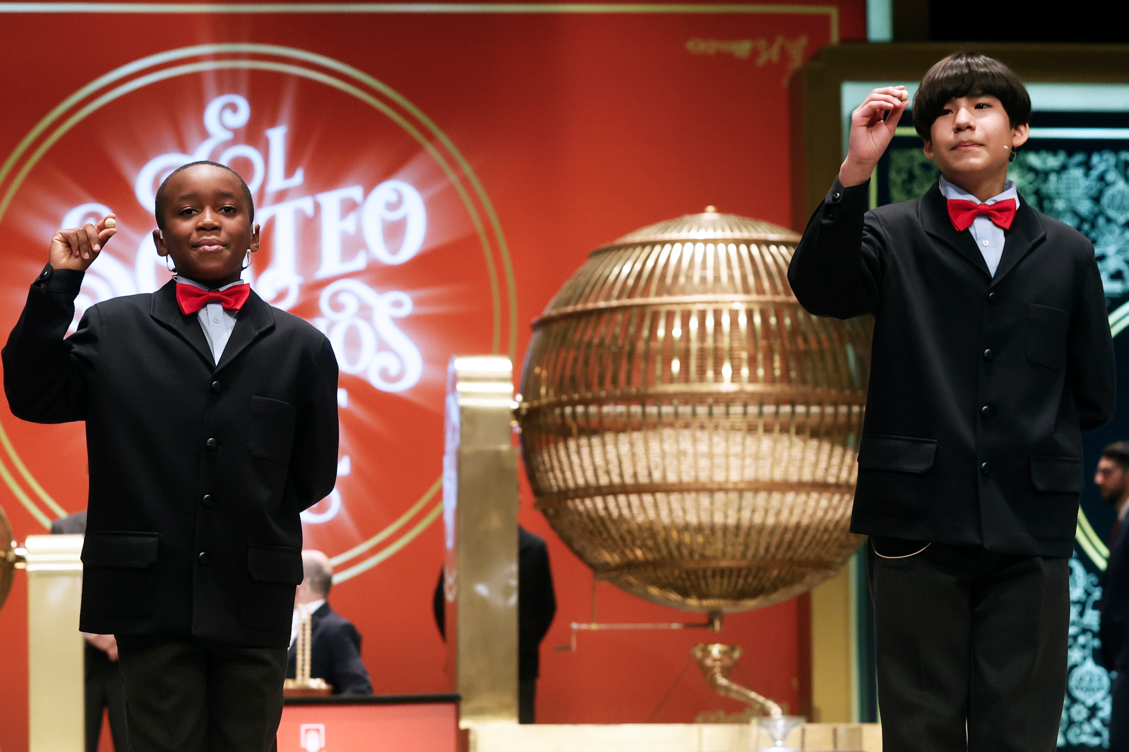 Desde la izquierda, Ángel Abaga Elebiyo y  Alonso Dávalos Durán cantan el premio Gordo de la Lotería de Navidad. El 05490 ha resultado premiado con el premio Gordo, que reparte 400.000 euros por décimo.