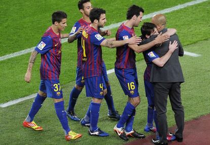 Barcelona's players celebrate with coach Josep Guardiola after scoring a goal against Espanyol.