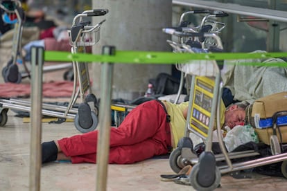 Una persona durmiendo en el suelo de la Terminal 4 de Barajas