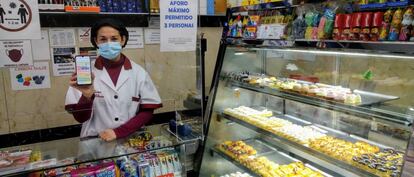 Nuria Carvajal, propietaria del horno La Gloria, muestra la aplicación desarrollada por la asociación de comerciantes de La Elipa, en Madrid.