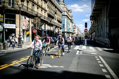 Parisienses percorrem a Rue de Rivoli de bicicleta.