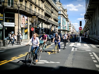 Parisienses percorrem a Rue de Rivoli de bicicleta.