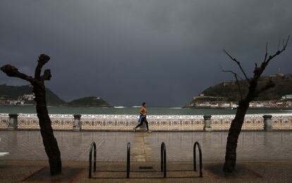 Un hombre hace deporte en la playa de la Concha de San Sebastián. Los cielos del País Vasco se presentan hoy cubiertos con precipitaciones persistentes generalizadas durante la primera mitad del día que serán de nieve a partir de los 500 o 600 metros, y que podrían alcanzar hasta los 10 centímetros, aunque la cota subirá hasta los 800 o 900 metros al final de la jornada.