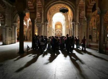 Un grupo de turistas contempla los arcos de la mezquita de Córdoba.