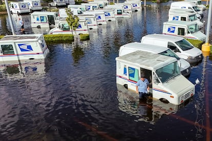 Un trabajador de USPS inspecciona los camiones de correos cubiertos por el agua tras el huracn Milton, este viernes en New Port Richey, Florida.