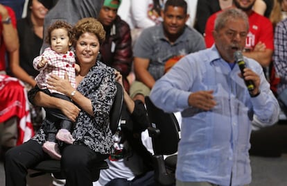 Dilma segura um bebê enquanto Lula discursa em evento da campanha em São Paulo.