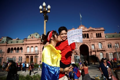 Una mujer besa a un ni?o que sostiene un cartel que dice "Queremos a Mara Corina", en Buenos Aires. 