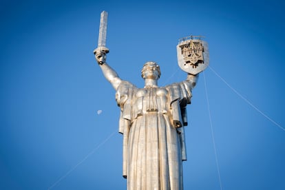 Workers install the Ukrainian coat of arms on the shield in the hand of the country's tallest stature, the Motherland Monument