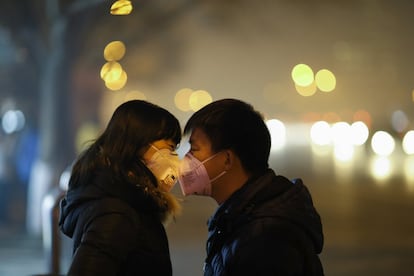 La capital china amaneció hoy envuelta en una densa capa de contaminación que mantiene a la metrópolis en alerta naranja, la segunda más grave tras la roja y la primera vez que se activa en lo que va de año, cuando se celebra en París la cumbre mundial contra el cambio climático. En la imagen, una pareja con máscaras faciales hablan en la estación de autobuses de Beijing.