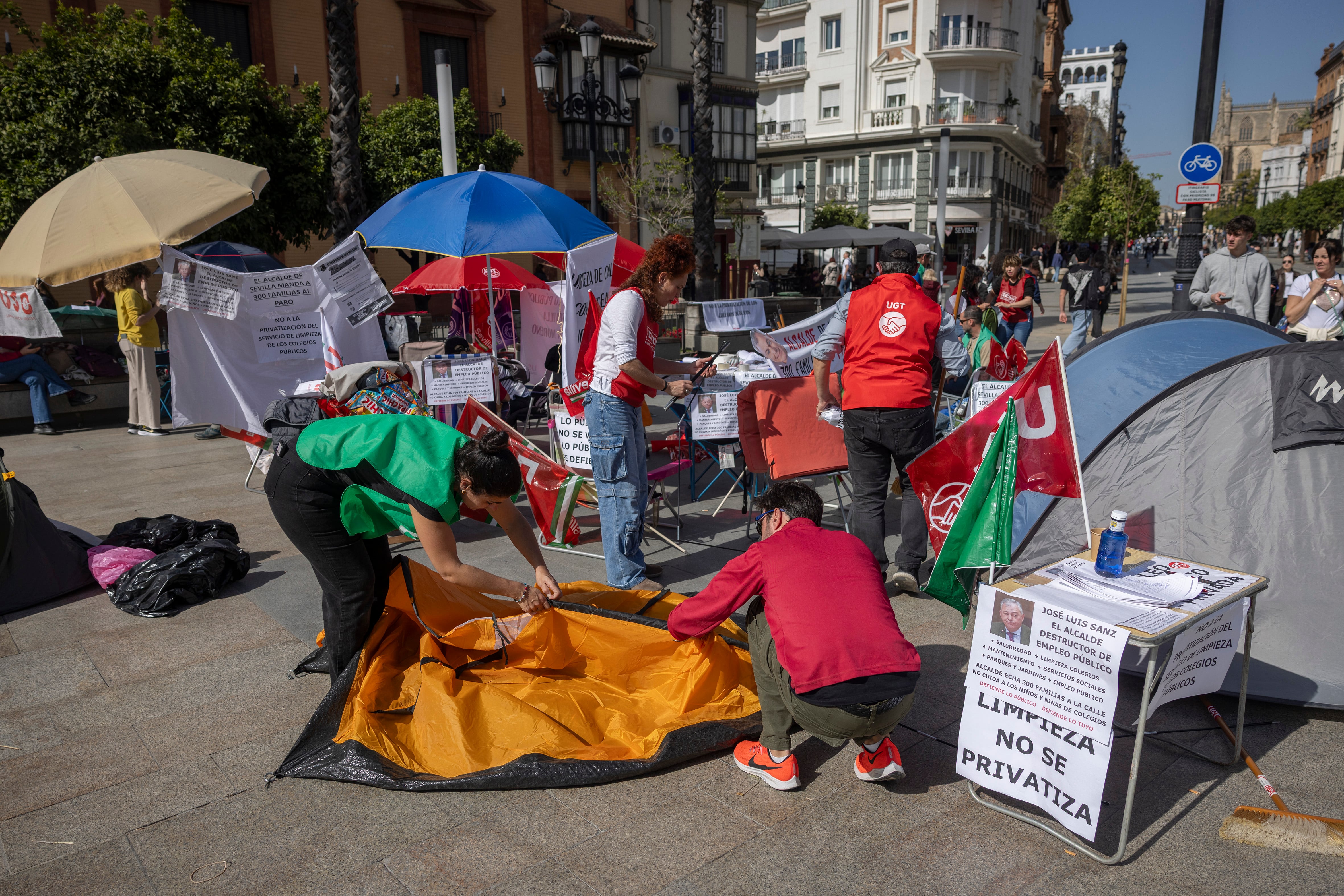 Participantes en la acampada convocada por el Comité de Empresa del Ayuntamiento de Sevilla en protesta contra la privatización del servicio, este martes en la Puerta de Jerez de la ciudad hispalense.