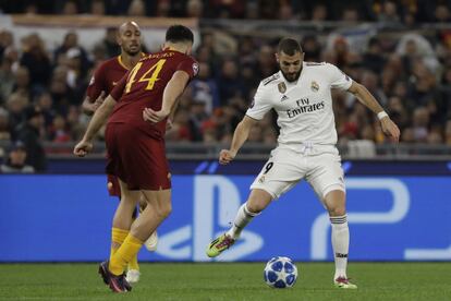 El delantero del Real Madrid, Karim Benzema, pasa el balón ante la presencia del defensa de la Roma, Kostas Manolas.