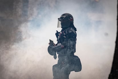 Los gases rodean a un miembro de la Policía durante el enfrentamiento. Los policías aparecen segundos después de que los estudiantes corten la carrera 30, como si estuvieran preparados. “Es por la fecha”, comenta un estudiante de Sociología. “¡Cerdos! ¡Cerdos!”, exclaman varios manifestantes.