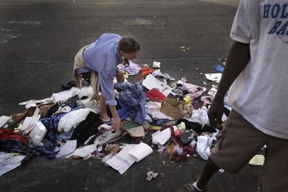 Uma mulher mexe no lixo em uma rua de Skid Row.