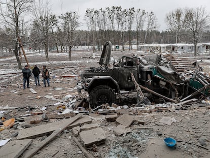 Personas paradas junto a un vehículo dañado en Brovary, cerca de Kiev, el pasado 1 de marzo.