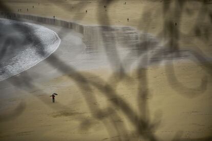 Escena de playa un día de lluvia en la playa de La Concha de San Sebastián, España.