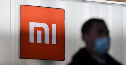 Un hombre pasa en Pekín junto a un logo de Xiaomi.