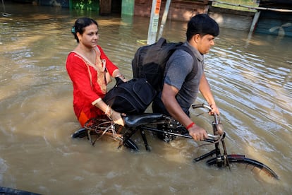 Una pareja en bicicleta el 19 de septiembre en la zona de Uday Narayanpu (India), que sufrió severas inundaciones provocadas por las fuertes lluvias.