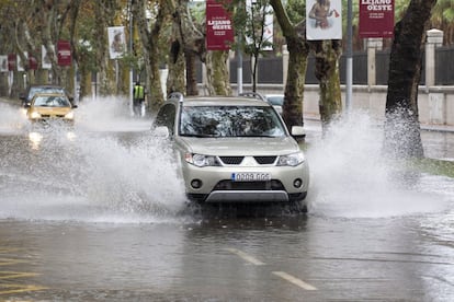 Un coche circula por una calle anegada de Málaga.