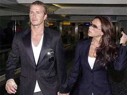 El jugador inglés y su mujer, Victoria Beckham, esperan hoy en el aeropuerto de Heatrow el vuelo a Tokio.
