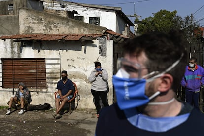 Un grupo de personas esperan a los voluntarios en una visita para detectar personas con síntomas del virus en Villa Fiorito (Buenos Aires).