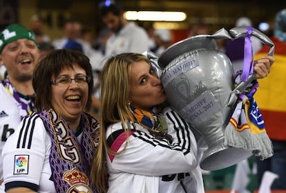 Torcedores do Real Madrid beija uma réplica da Copa da Europa momentos antes do partida.