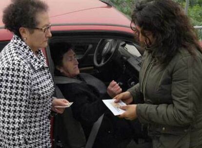 La presidenta de una mesa recoge el voto de una mujer impedida.