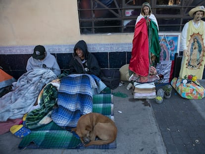 Dos peregrinos descansan cerca de la Basílica con su perro, el 11 de diciembre.