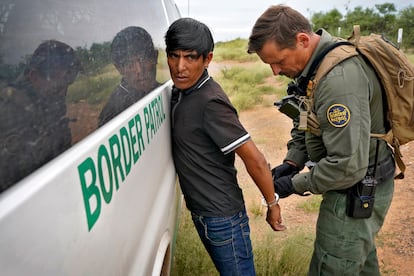 Un agente de la Patrulla Fronteriza estadounidense quita las esposas a un migrante detenido para que éste sea transportado, el pasado 8 de septiembre, cerca de Sasabe, Arizona (EE UU).