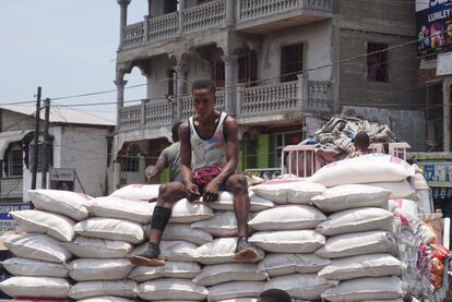 Un hombre sentado sobre sacos de arroz en un mercado en Freetown el 6 de abril de 2022, los precios de los productos básicos han subido en Sierra Leona desde la pandemia de covid-19 y más aún por la invasión rusa de Ucrania.
