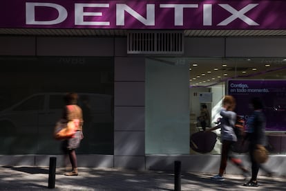 Varias personas pasean, este viernes, por delante de la clínica dental de Dentix en la calle Alcalá (Madrid).