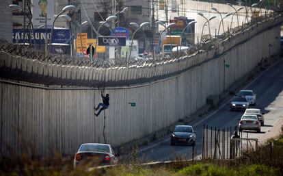 Un palestino utiliza una cuerda para saltar el muro de separacin de Israel en la ciudad cisjordana de al-Ram.