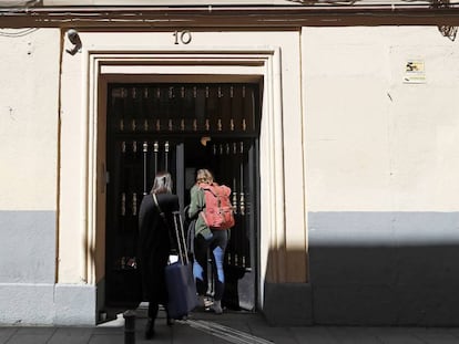Dos personas entran a un piso de alquiler turístico, en la calle de Encomienda 10, en Madrid.