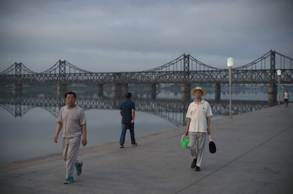 Viandantes cerca del Puente de la Amistad Sinocoreana que conecta Corea del Norte y China, en la ciudad china de Dandong.