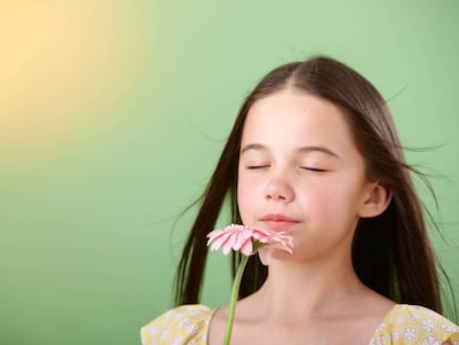 Una ni&ntilde;a huele una flor.