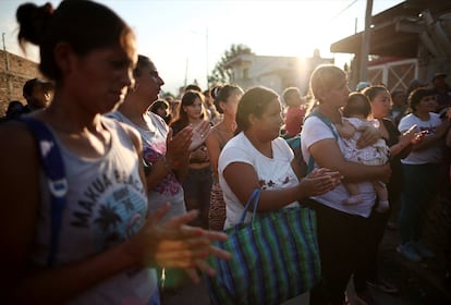 Argentinos rezan antes de recibir una bolsa de alimentos de caridad en Villa Fiorito, un barrio de clase trabajadora en las afueras de Buenos Aires, Argentina, el  27 de febrero.