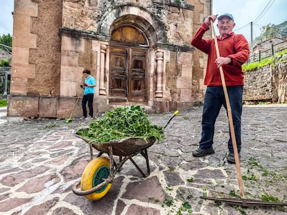 Varios vecinos de Tresviso limpiando alrededor de la iglesia del pueblo.