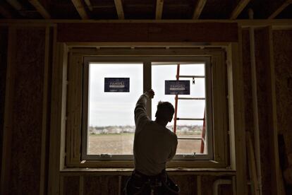 Un contratista instala una ventana durante la construcción de una nueva casa en Dunlap, Illinois.