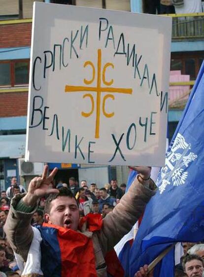 Un ultranacionalista serbio porta una pancarta de apoyo a su partido en Mitrovica.