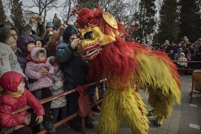 El público interactúa con los bailarines tradicionales durante la danza del dragón, en Pekín (China).