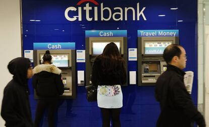 Clientes sacan dinero de un cajero de Citibank en Londres. 
