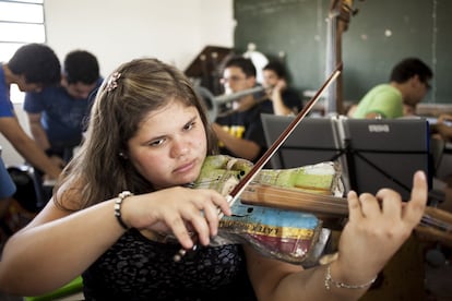 Foto del 12 de marzo de 2014. Asunción (Paraguay). Una niña toca su violín reciclado durante un ensayo de la Orquesta de Instrumentos Reciclados de Cateura. La mítica banda de rock estadounidense Metallica eligió hacer su gira por Suramérica con un peculiar grupo telonero, una humilde orquesta juvenil de Paraguay que toca con instrumentos reciclados del vertedero de su barrio. 


