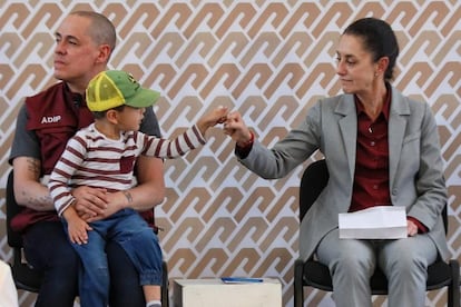 José Antonio Peña Merino holds his son with Claudia Sheinbaum during an official event at the Iztacalco mayor's office, in September 2022.  