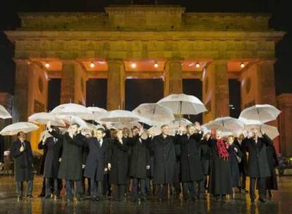 Dirigentes internacionales asistentes al 20º aniversario de la caída del Muro saludan ante la Puerta de Brandeburgo.