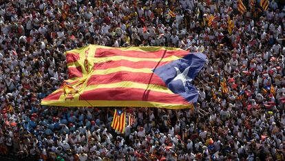 Una inmensa bandera estelada pasa entre las manos de los participantes en una celebraci&oacute;n de la Diada. 